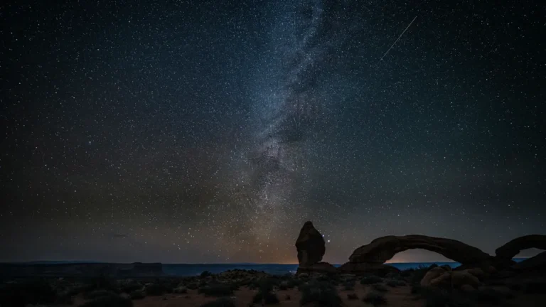 The Milky Way over red rock desert arches at a dark sky park