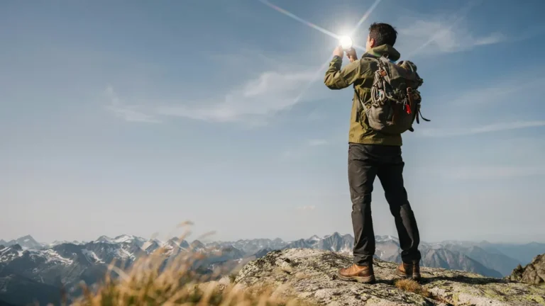Hiker signaling with a mirror on a ridge
