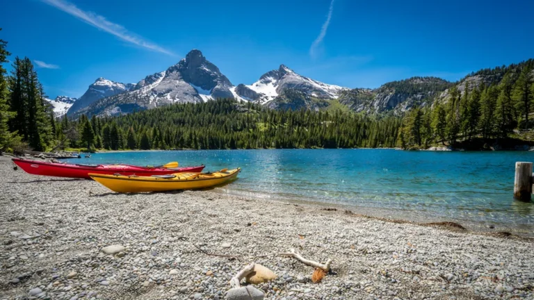 Colorful kayaks on the shore of a turquoise mountain lake