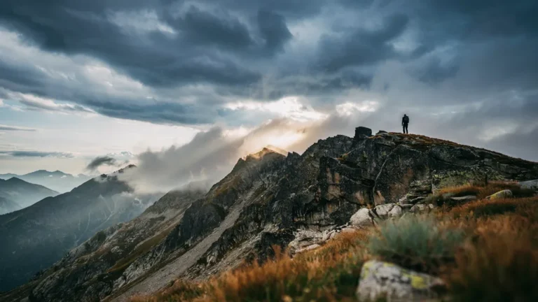 Dramatic storm clouds and sun over a mountain ridgeline